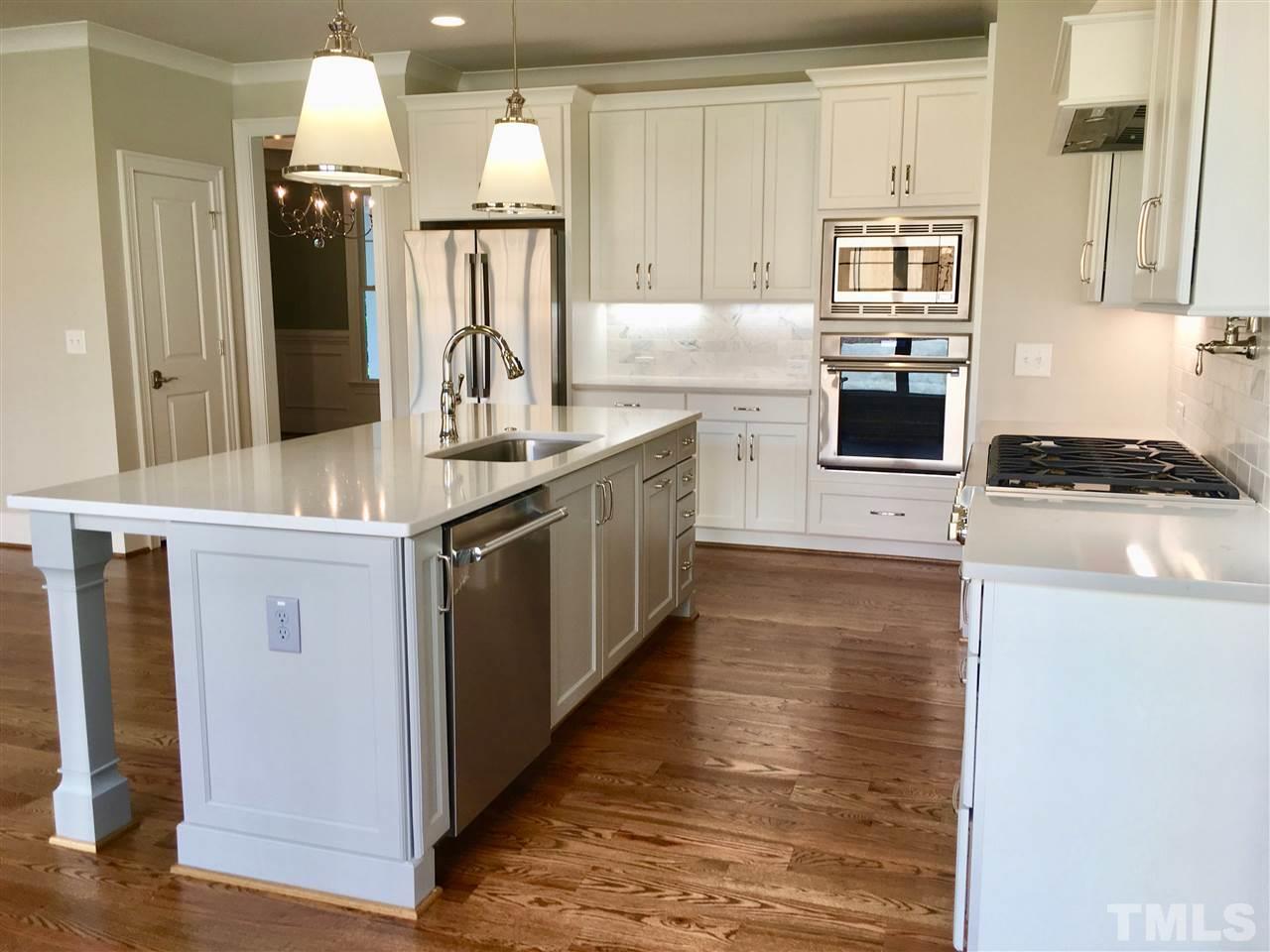 1501 Nottingham Road Raleigh, NC 27607 - Photo 7 of 25 a kitchen with kitchen island granite countertop a stove and a refrigerator
