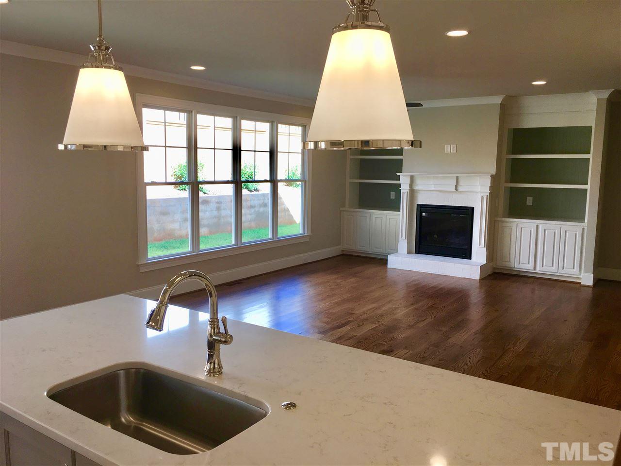 1501 Nottingham Road Raleigh, NC 27607 - Photo 8 of 25 a kitchen with kitchen island a sink wooden floor and a large window