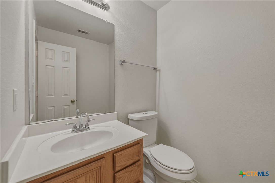 109 Comal Cove Elgin, TX 78621 - Photo 8 of 34 a bathroom with a sink a toilet and a mirror