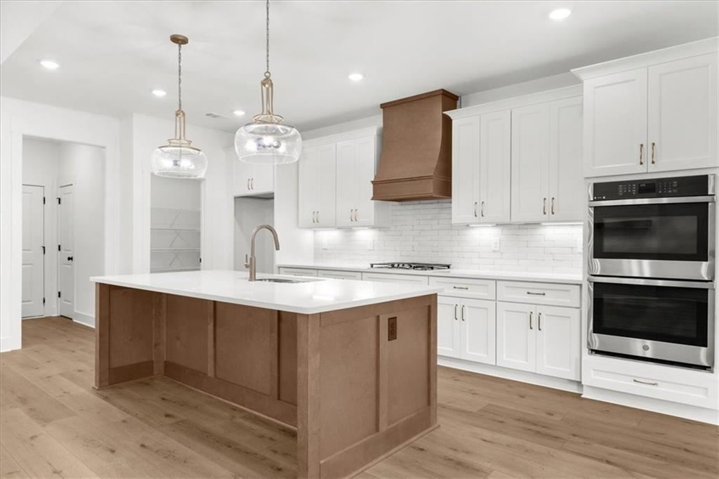 504 Level Creek Road Sugar Hill, GA 30518 - Photo 9 of 54 a kitchen with stainless steel appliances granite countertop a sink a stove a refrigerator and island with wooden floor