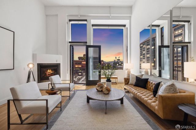 a living room with furniture fireplace and a large window