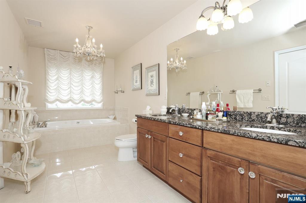 108 Demarest Lane Montvale, NJ 07645 - Photo 12 of 17 a spacious bathroom with a granite countertop sink a large mirror and a bathtub
