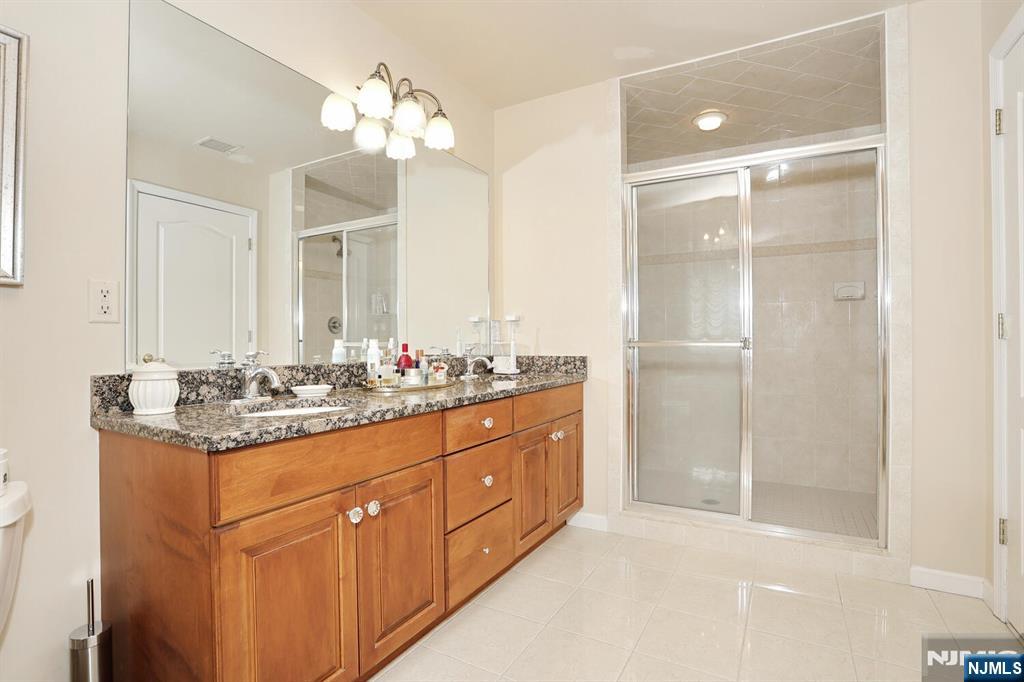 108 Demarest Lane Montvale, NJ 07645 - Photo 13 of 17 a bathroom with a granite countertop sink a large mirror and a shower