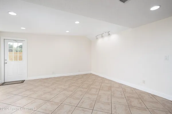an empty room with white walls and tiles