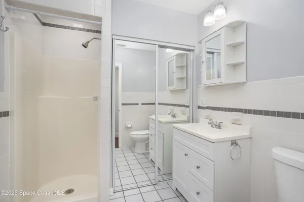a spacious bathroom with a shower sink mirror and toilet