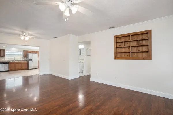 a view of an empty room with window and wooden floor
