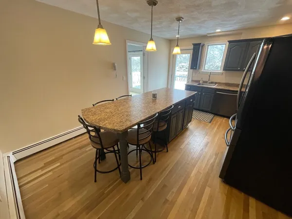 a dining room with granite countertop furniture and a chandelier
