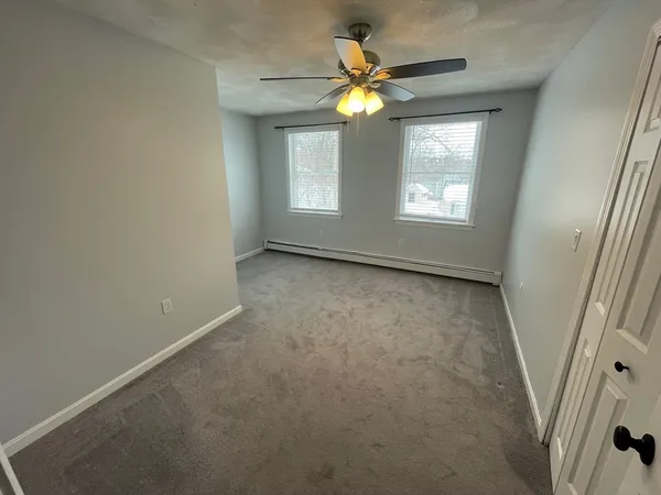 an empty room with a ceiling fan and a window