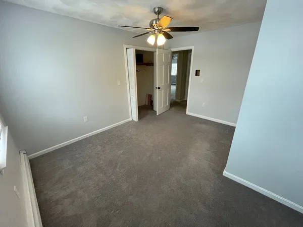 en empty room with windows and fan