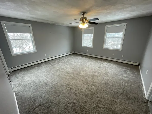 an empty room with a ceiling fan and bathroom view