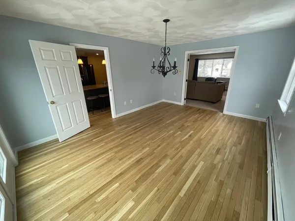 a view of empty room with window and wooden floor