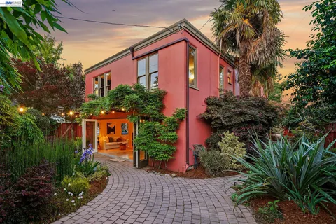 a front view of a house with plants and trees