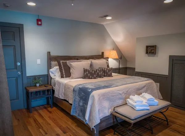 a bedroom with a bed and wooden floor