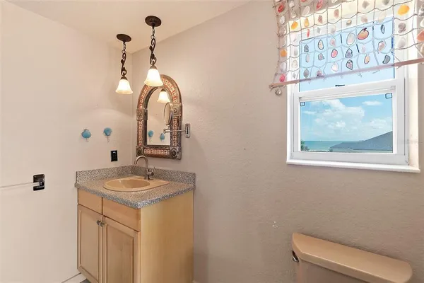 a view of an empty room with window and chandelier fan