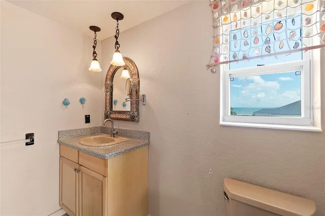 a view of an empty room with window and chandelier fan