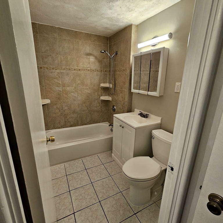 245 Boston Post Road East, Unit 7 Northborough, MA 01532 - Photo 6 of 10 a bathroom with a granite countertop toilet a sink and a mirror