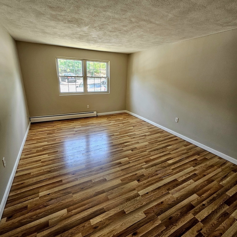 245 Boston Post Road East, Unit 7 Northborough, MA 01532 - Photo 9 of 10 a view of an empty room with wooden floor and a window