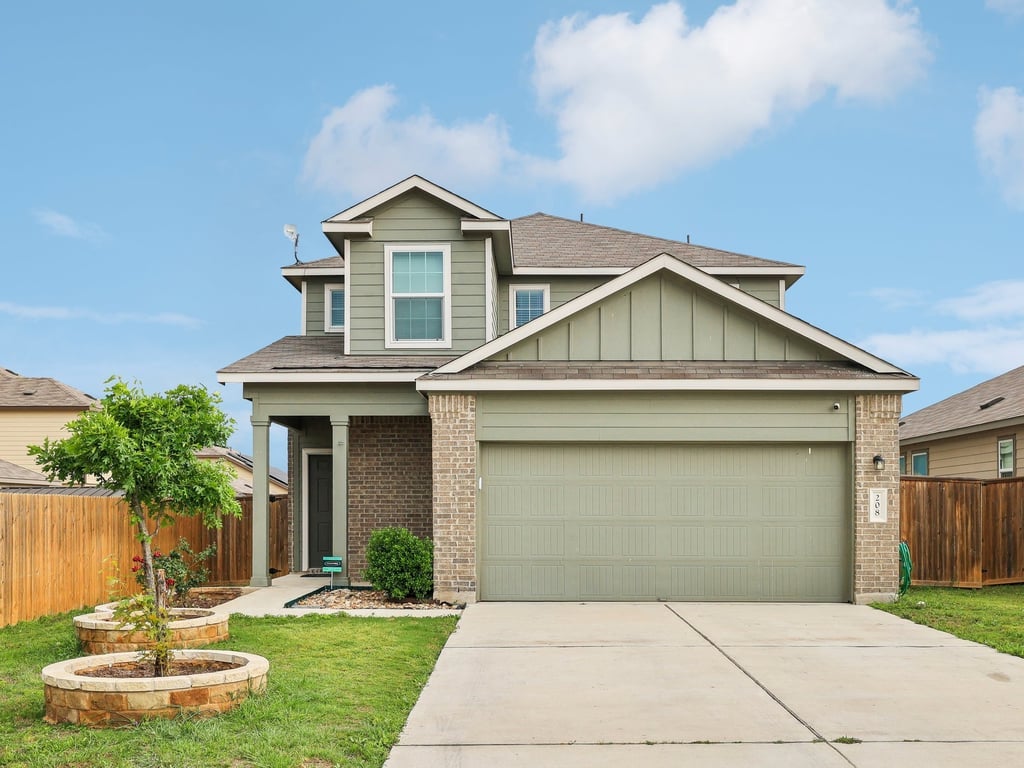 a front view of a house with a yard and garage
