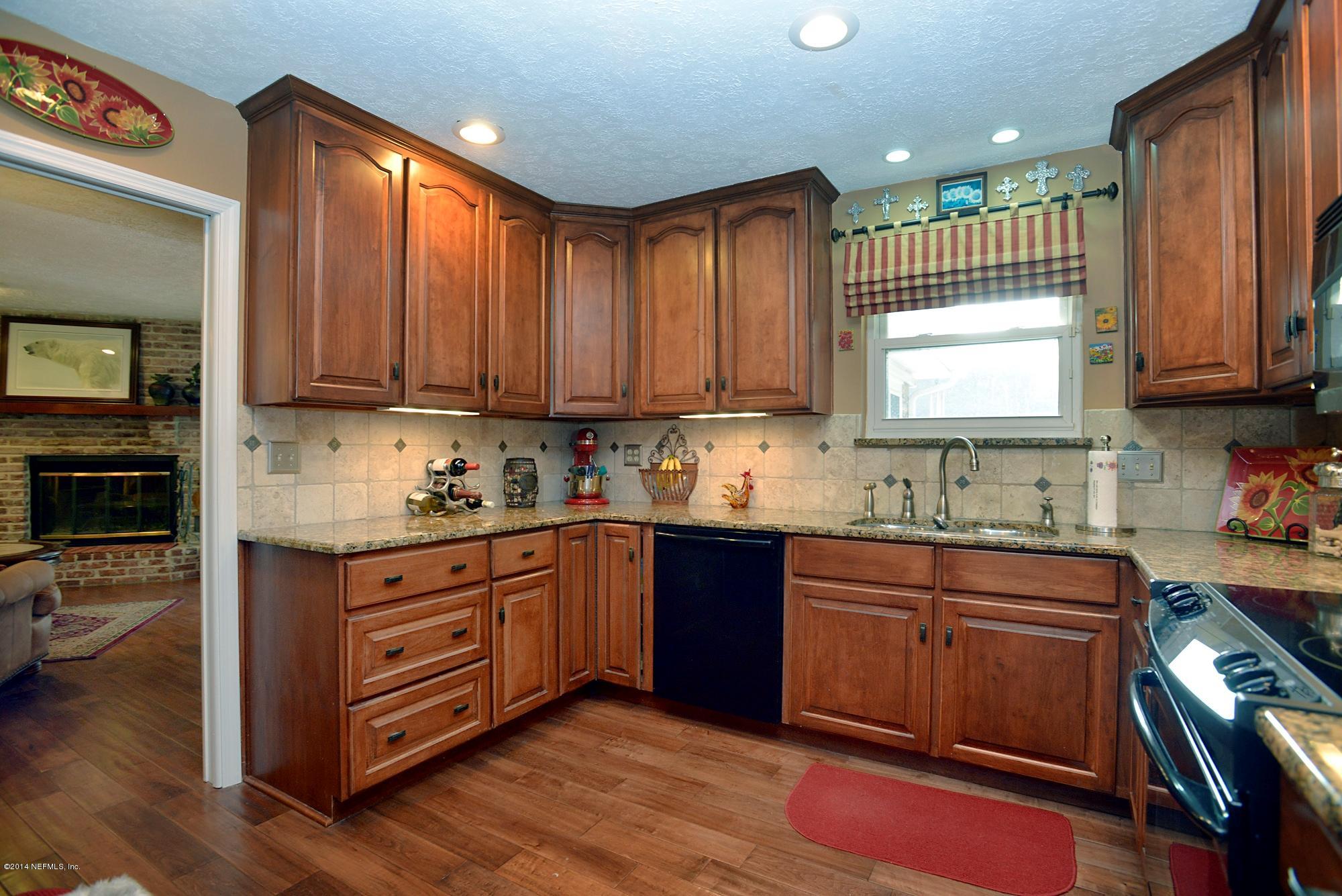 11330 Scott Mill Road Jacksonville, FL 32223 - Photo 11 of 28 a kitchen with granite countertop wooden cabinets stainless steel appliances a sink and a window