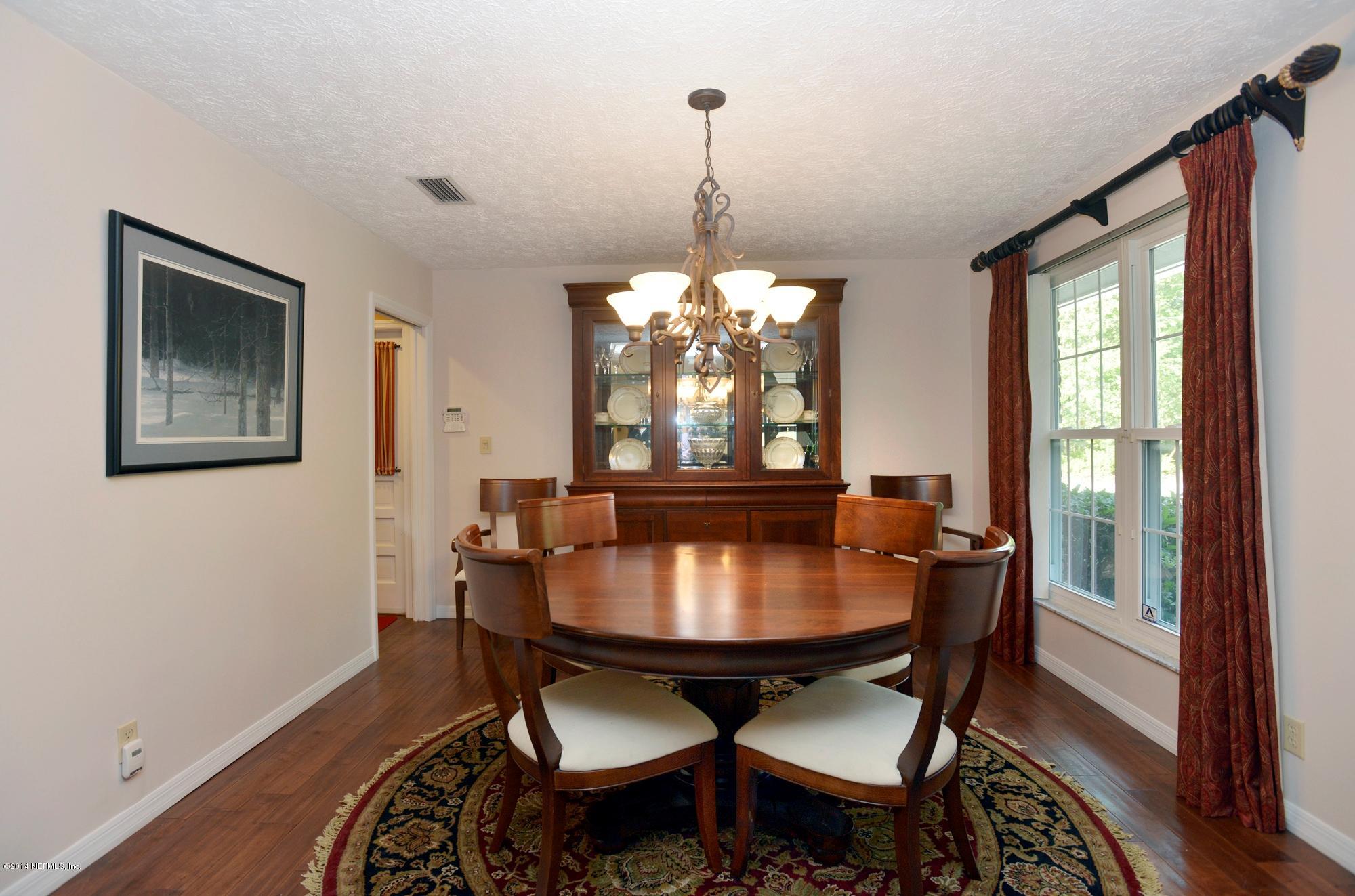 11330 Scott Mill Road Jacksonville, FL 32223 - Photo 9 of 28 a dining room with furniture a chandelier and wooden floor