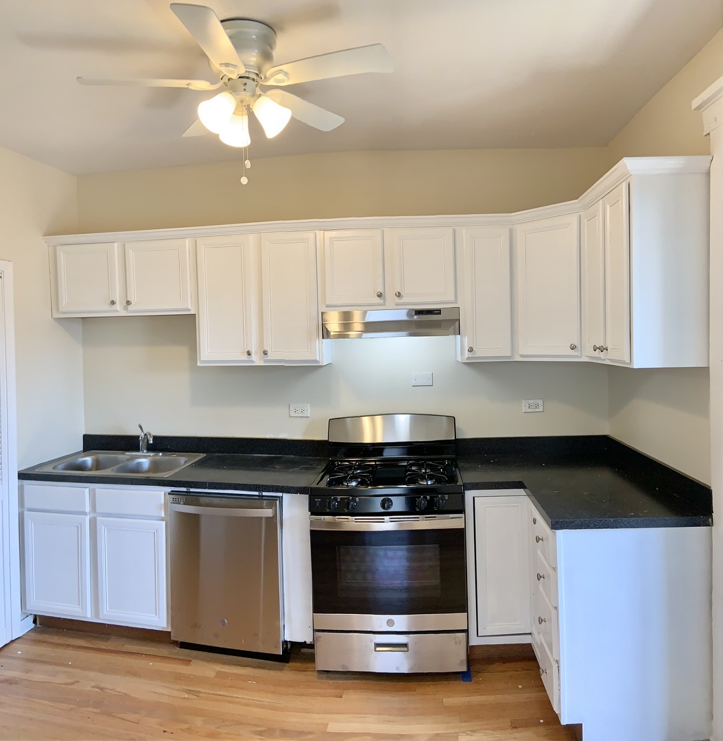 4847 West Hutchinson Street, Unit 2 Chicago, IL 60641 - Photo 2 of 8 a kitchen with cabinets appliances and a sink