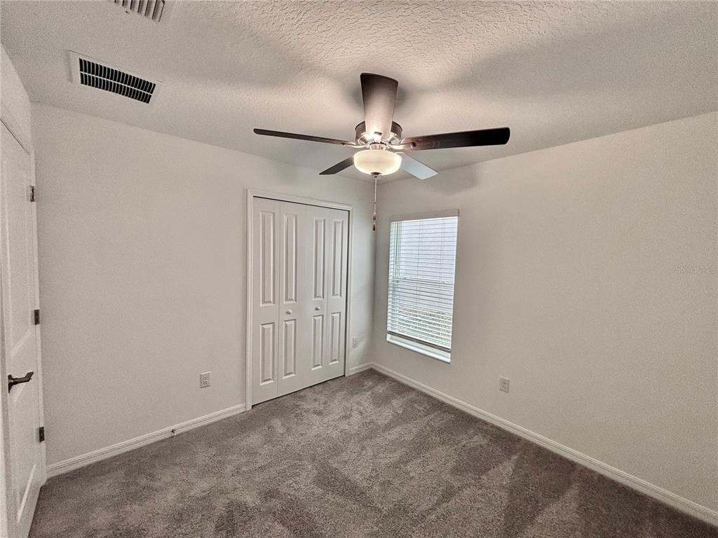 11237 Linden Depot Road San Antonio, FL 33576 - Photo 16 of 31 an empty room with windows and fan
