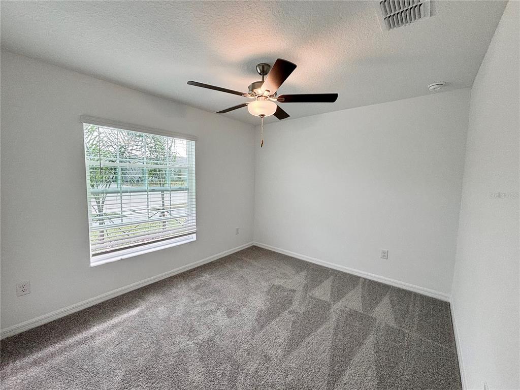 11237 Linden Depot Road San Antonio, FL 33576 - Photo 17 of 31 an empty room with windows and fan