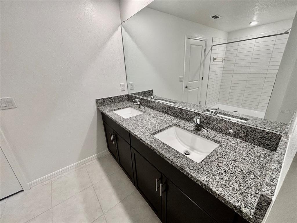 11237 Linden Depot Road San Antonio, FL 33576 - Photo 18 of 31 a bathroom with a granite countertop sink and a mirror