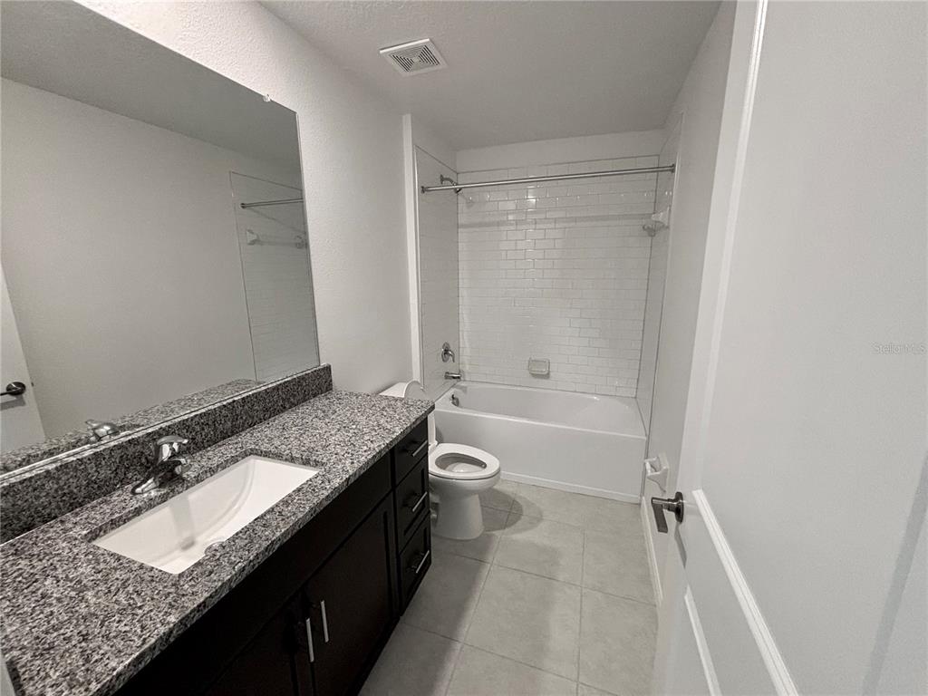 11237 Linden Depot Road San Antonio, FL 33576 - Photo 21 of 31 a bathroom with a granite countertop sink a toilet and shower