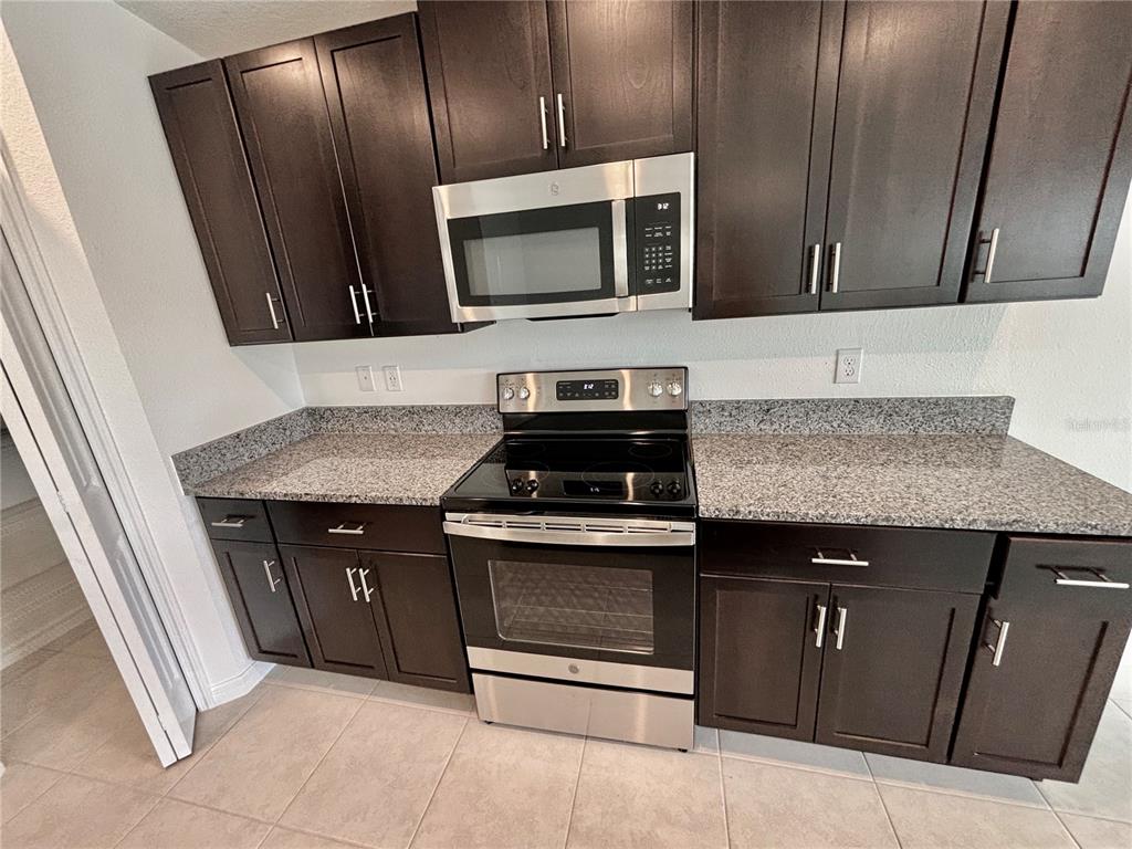 11237 Linden Depot Road San Antonio, FL 33576 - Photo 7 of 31 a kitchen with granite countertop stainless steel appliances and sink