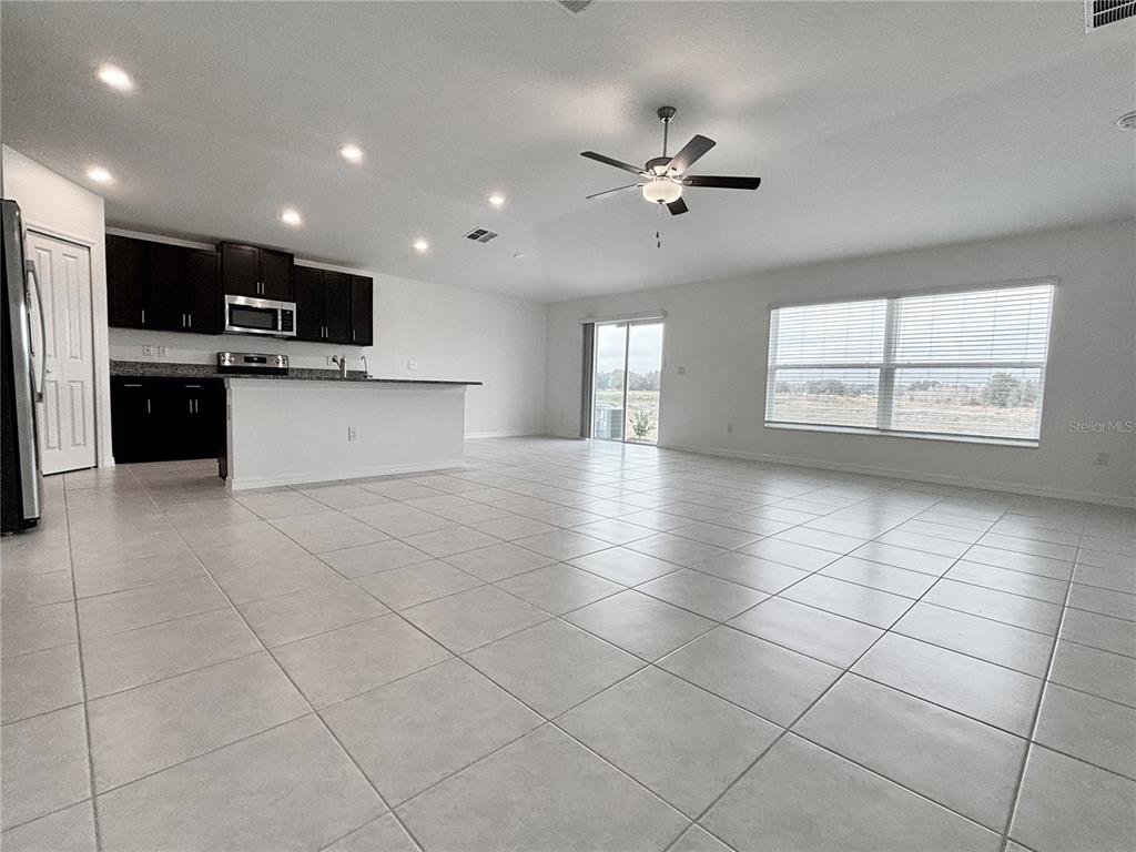 11237 Linden Depot Road San Antonio, FL 33576 - Photo 10 of 31 a large white kitchen with stainless steel appliances kitchen island granite countertop a sink and a stove