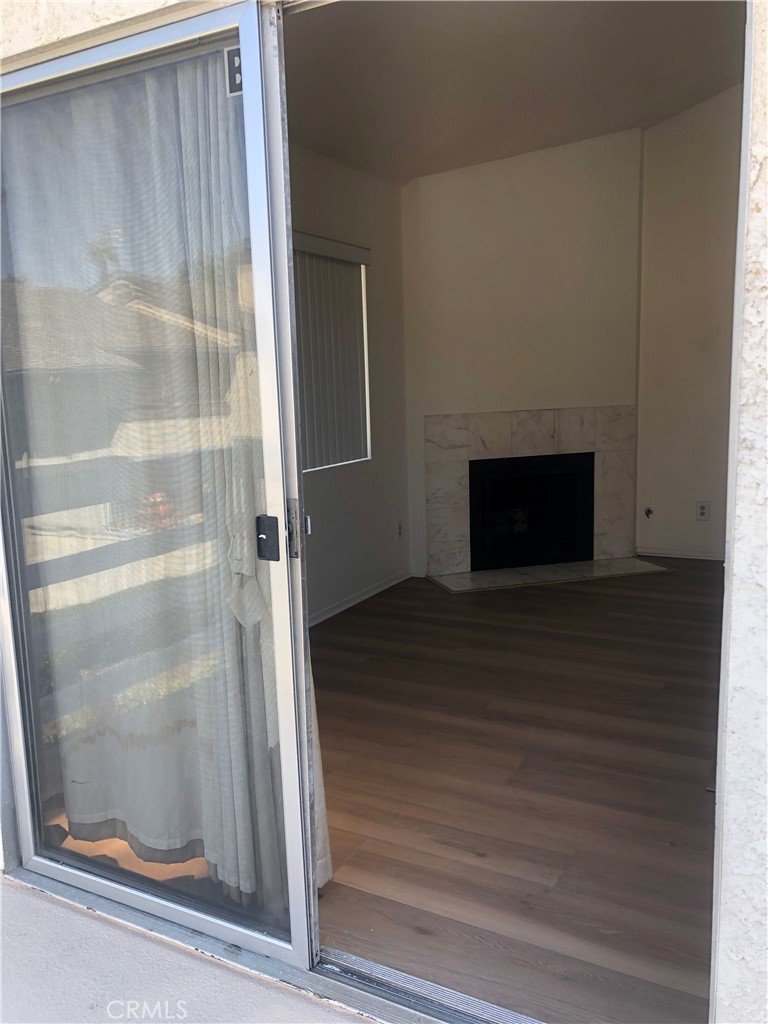 16621 Dolores Lane, Unit B Huntington Beach, CA 92649 - Photo 4 of 22 a view of a hallway with wooden floor and a fireplace