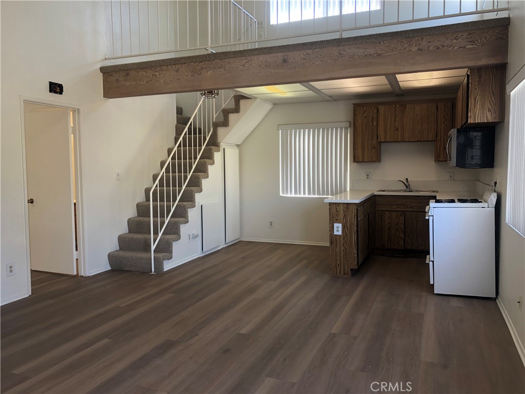 16621 Dolores Lane, Unit B Huntington Beach, CA 92649 - Photo 7 of 22 a view of a kitchen with furniture and a wooden floor