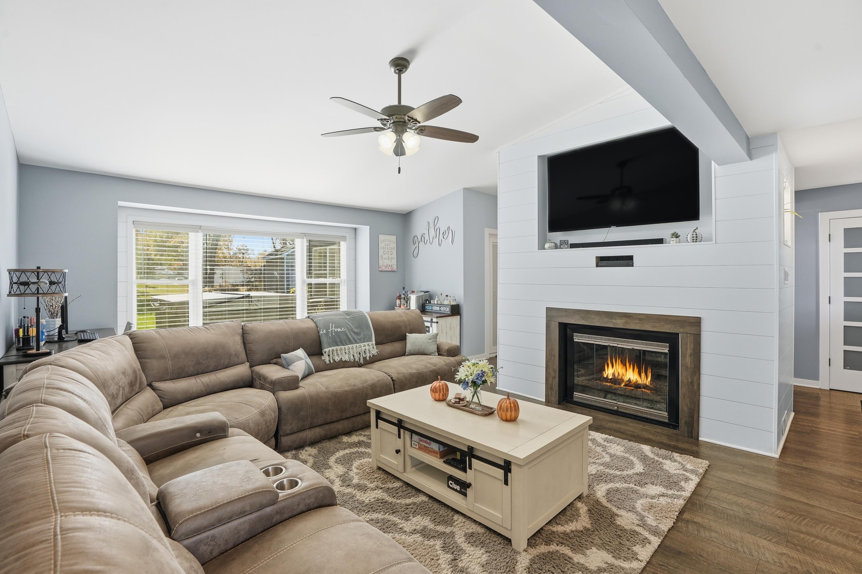 3725 West 105th Avenue Crown Point, IN 46307 - Photo 5 of 37 a living room with furniture a flat screen tv and a fireplace
