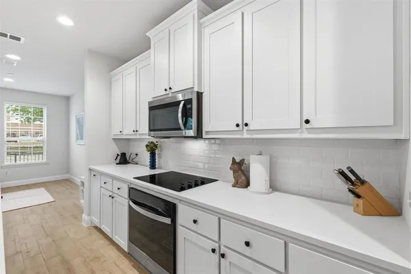 a kitchen with stainless steel appliances white cabinets and a sink