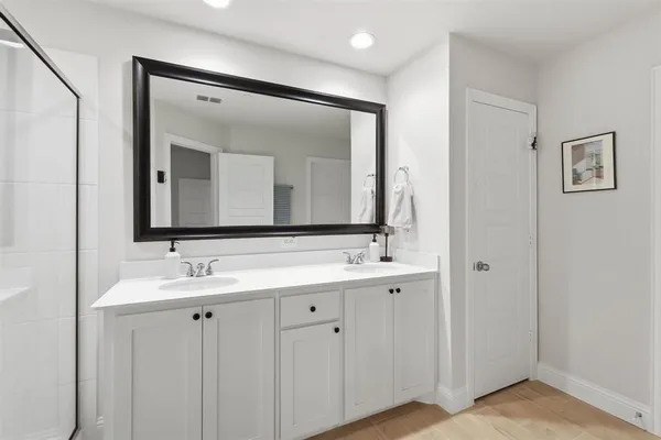 a bathroom with a double vanity sink and a mirror