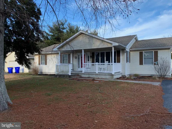 a front view of a house with a garden and yard