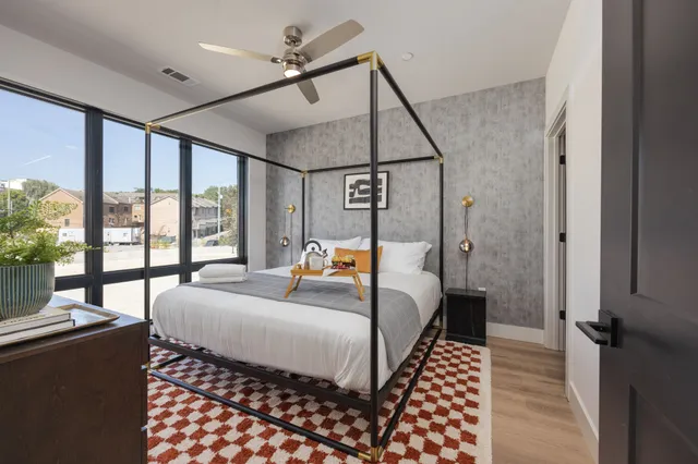 a bedroom with a bed and wooden floor