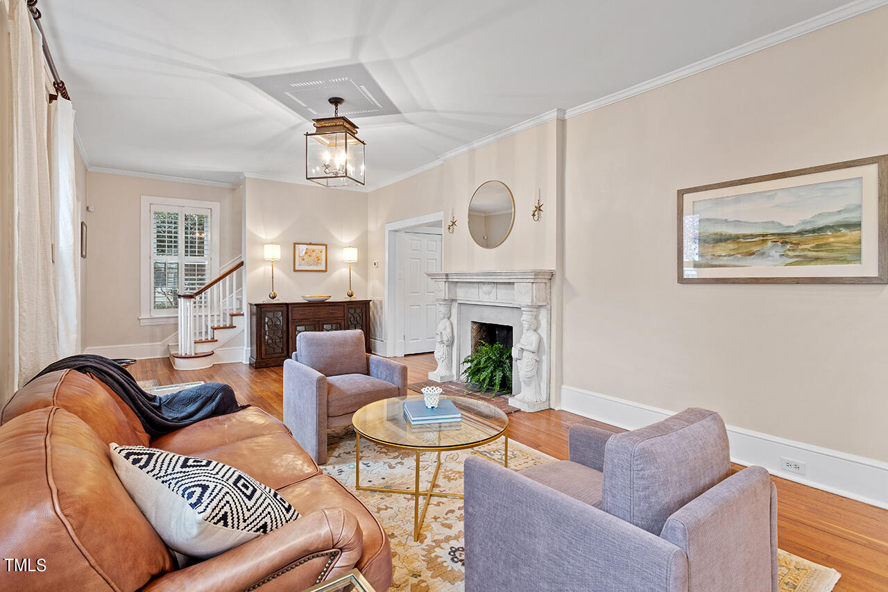 1310 Williamson Drive Raleigh, NC 27608 - Photo 13 of 43 a living room with furniture a fireplace and a chandelier