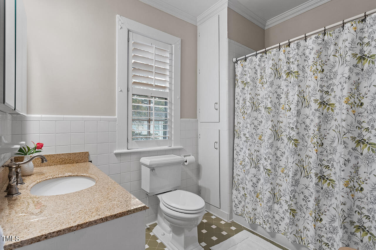 1310 Williamson Drive Raleigh, NC 27608 - Photo 29 of 43 a bathroom with a granite countertop sink toilet and shower