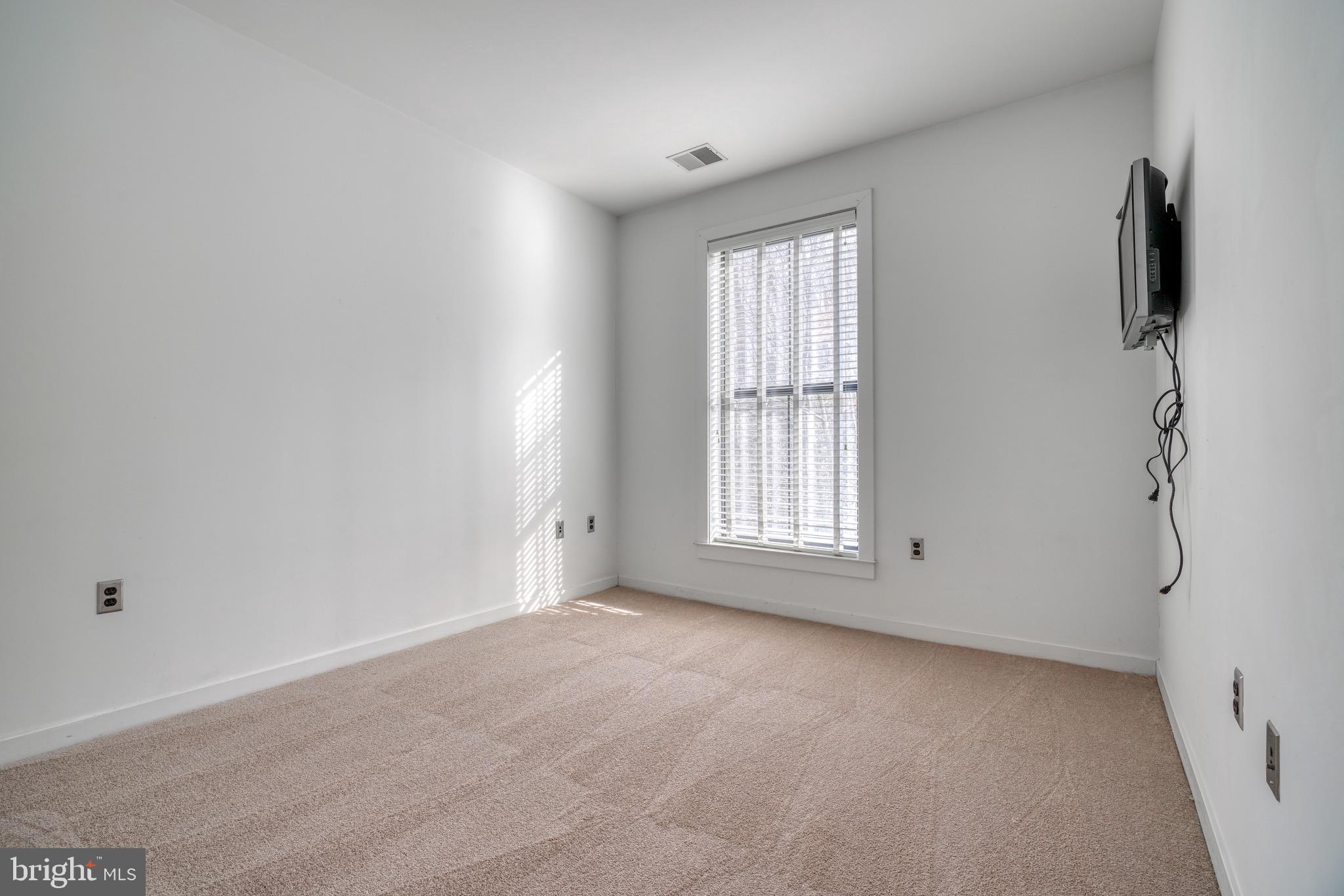 2007 Clipper Park Road, Unit 123 Baltimore, MD 21211 - Photo 13 of 25 wooden floor in an empty room with a window