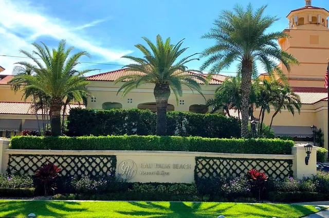 a view of a white house with a big yard and potted plants