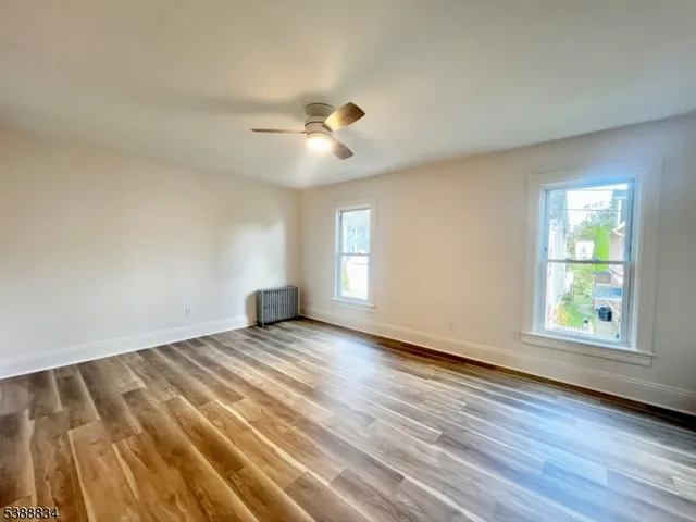 a view of empty room with wooden floor
