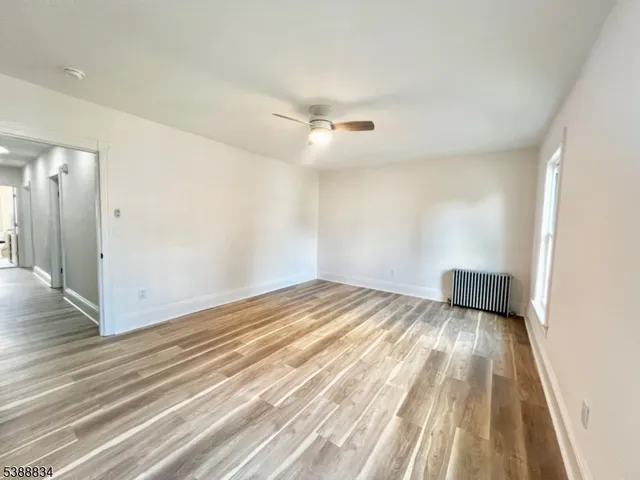 a view of a livingroom with wooden floor and a ceiling fan