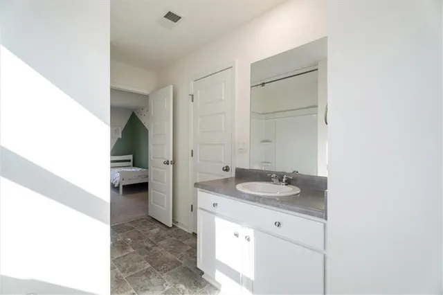 a bathroom with a granite countertop sink and a mirror