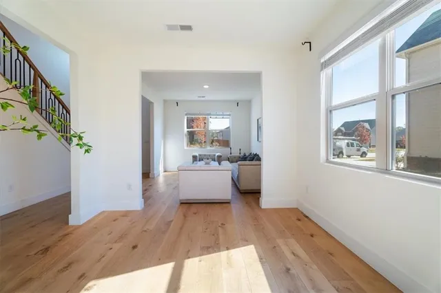 a view of kitchen with kitchen island wooden floor and stainless steel appliances