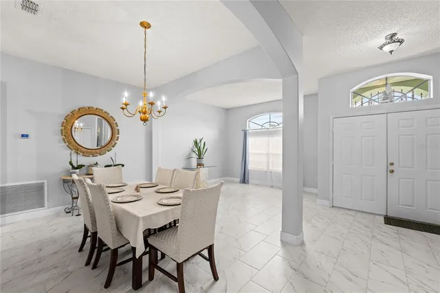 a view of a dining room with furniture a chandelier and wooden floor