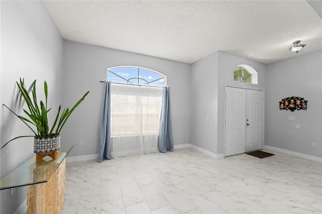 a living room with furniture kitchen view and a window