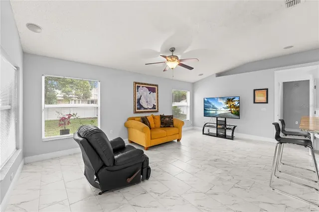 a kitchen with stainless steel appliances a table chairs refrigerator and cabinets
