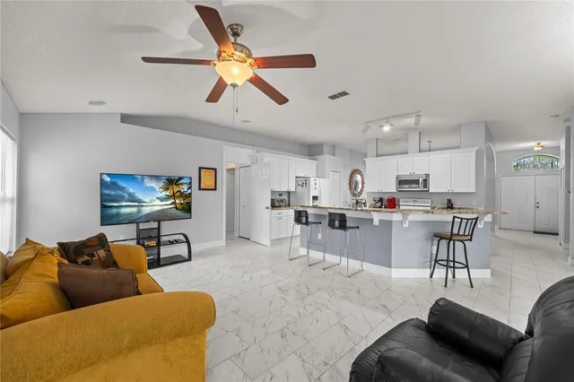 a kitchen with kitchen island granite countertop a sink cabinets and stainless steel appliances